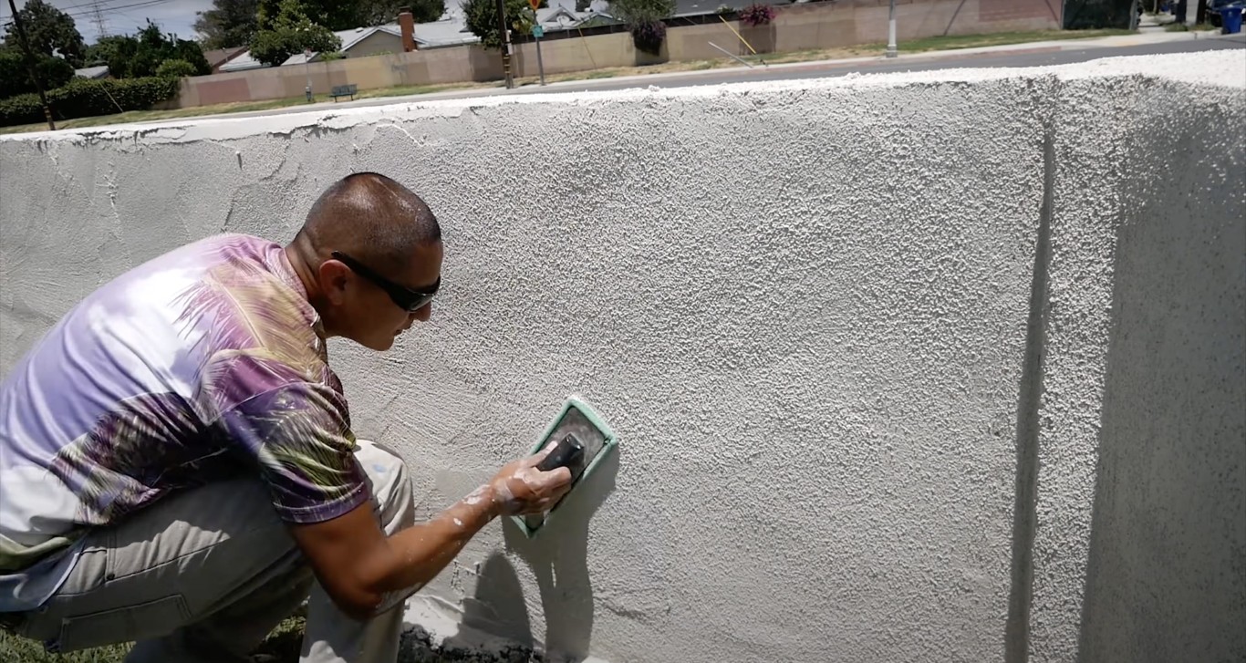Skilled concrete worker applying professional finish to wall surface